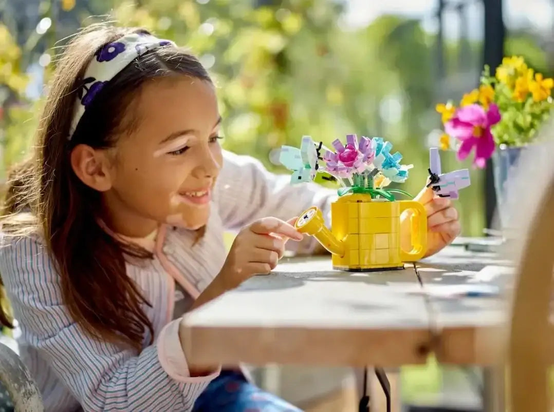 Dziewczynka bawi się kreatywną zabawką LEGO, konewka z kwiatami - zabawki-dla-dziewczynki