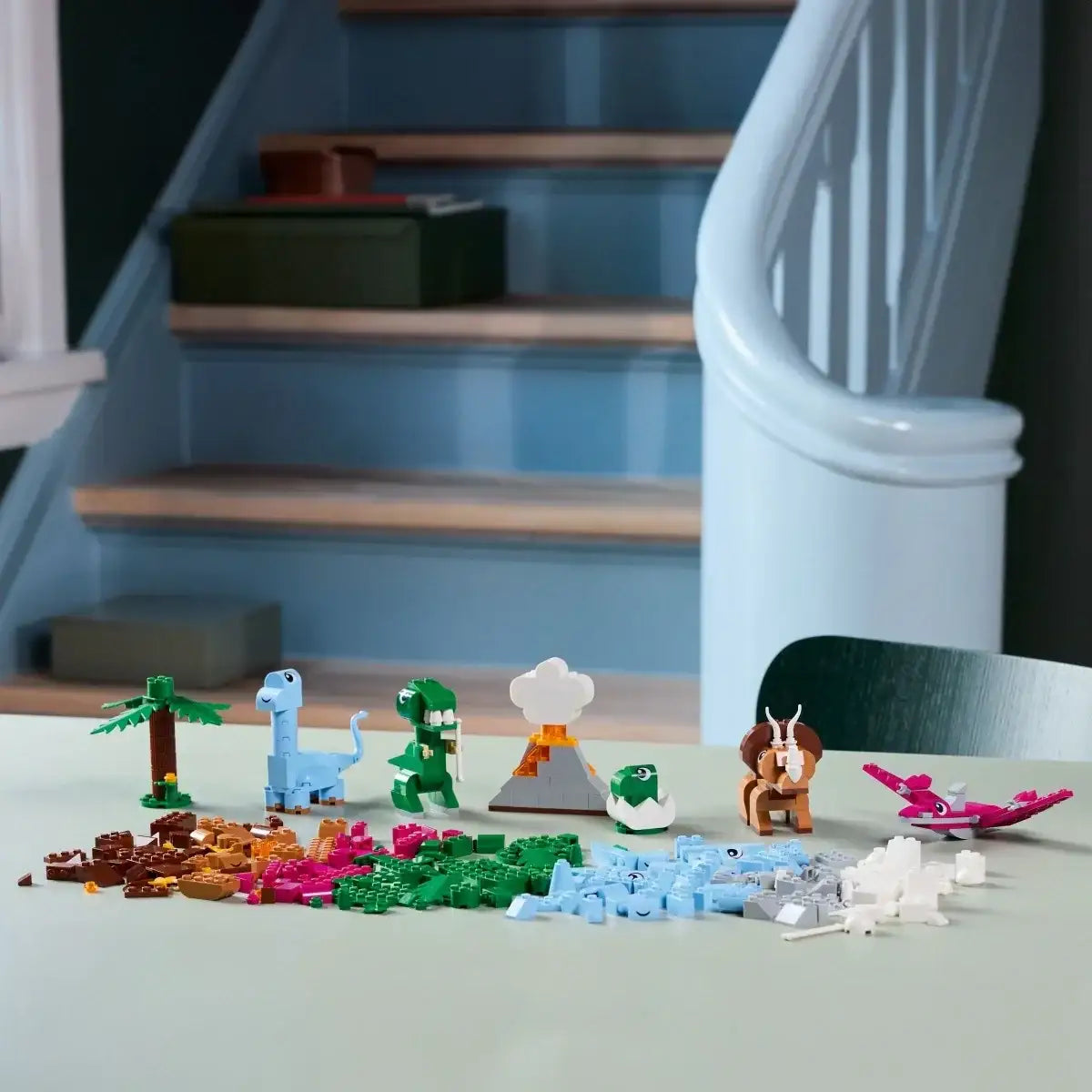 Kolorowe klocki LEGO dinozaury i wulkan na stole, zabawki kreatywne dla dziewczynki  - zabawki-dla-dziewczynki