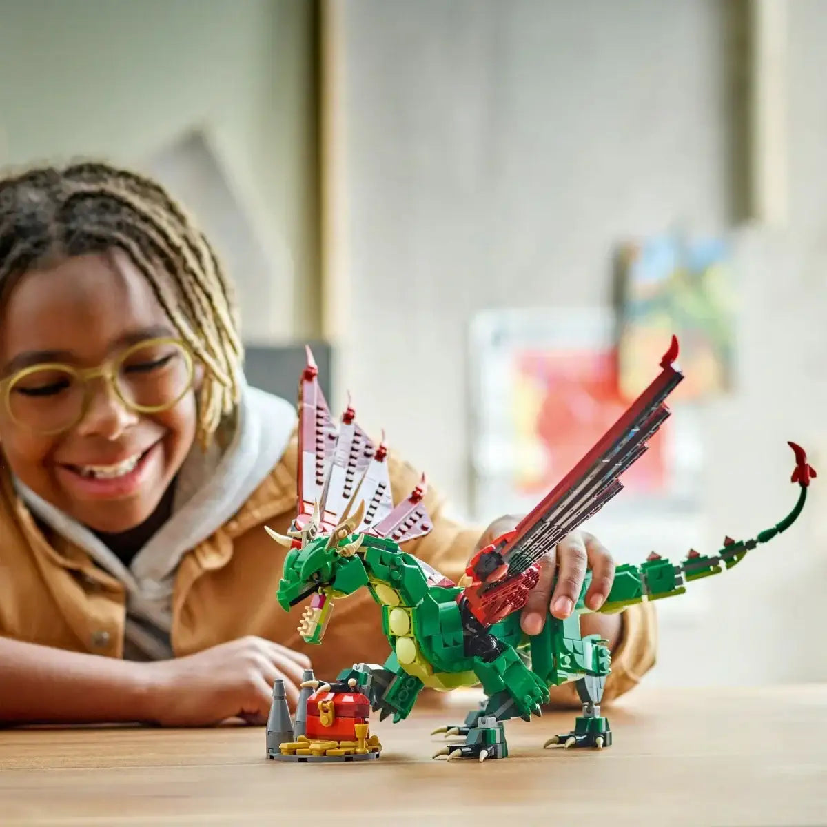 Dziewczynka bawi się kreatywną zabawką LEGO, zielonym smokiem na stole, zabawki dla dziewczynki - zabawki-dla-dziewczynki